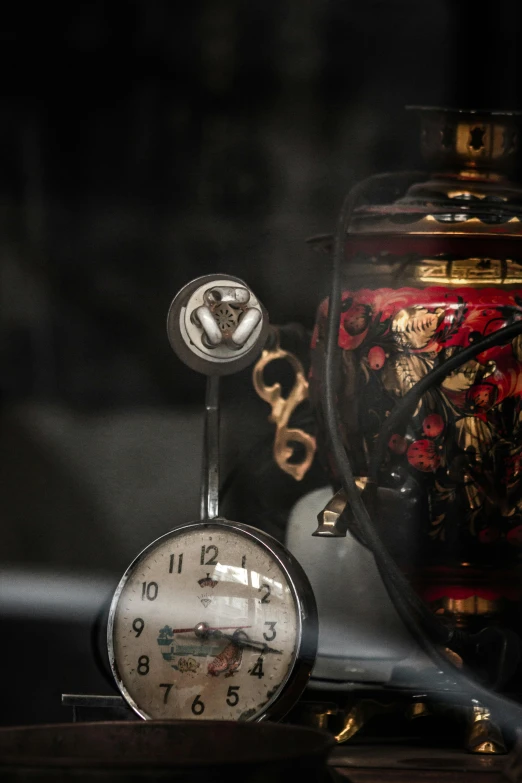 a clock is sitting next to a jar and two glass clocks