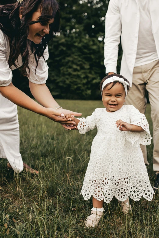 two children stand and hold hands as an adult puts on gloves