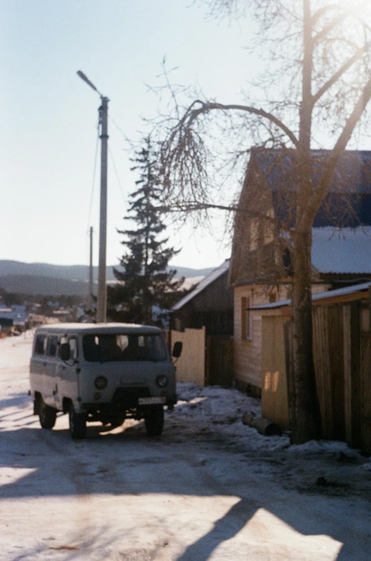 a white truck driving down a road past buildings