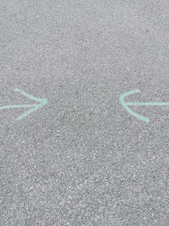 arrows point in different directions on a concrete road