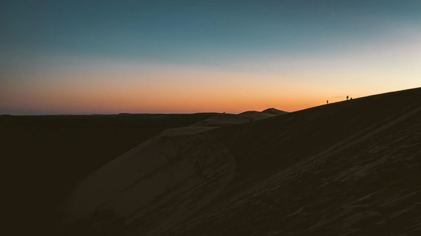 the silhouette of a skier is shown at dusk