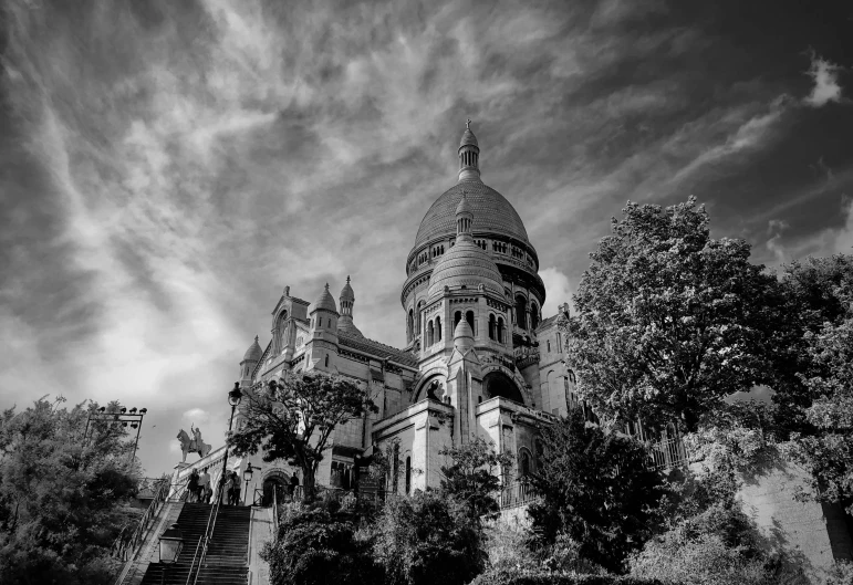 a church with stairs and trees in the foreground