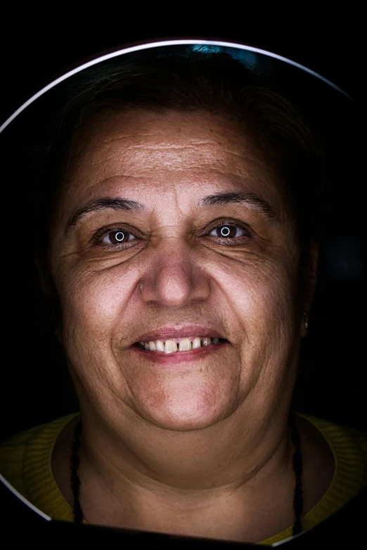 a person in a circular mirror looking into the camera