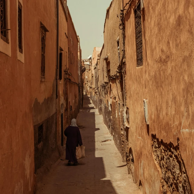 a person walking down an alley way between some buildings