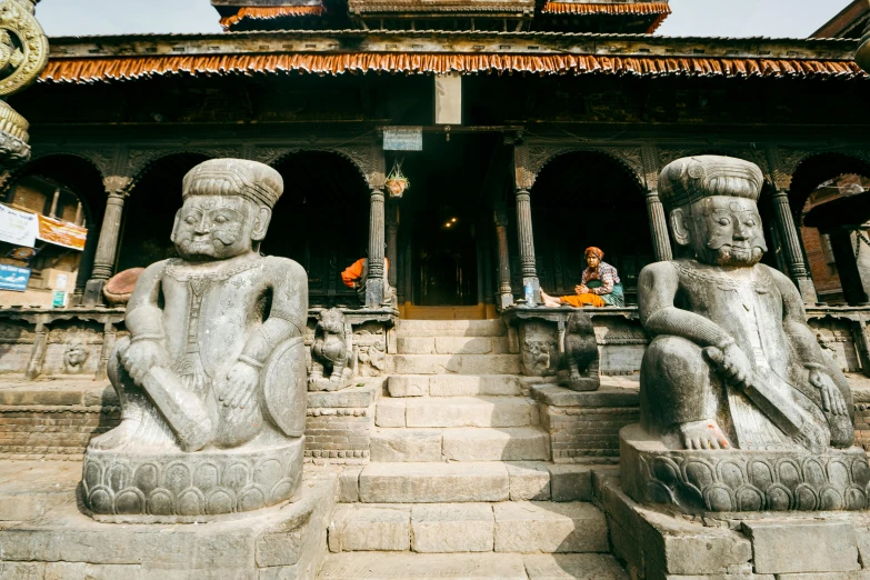 statues of sitting buddhas sit in front of a large building