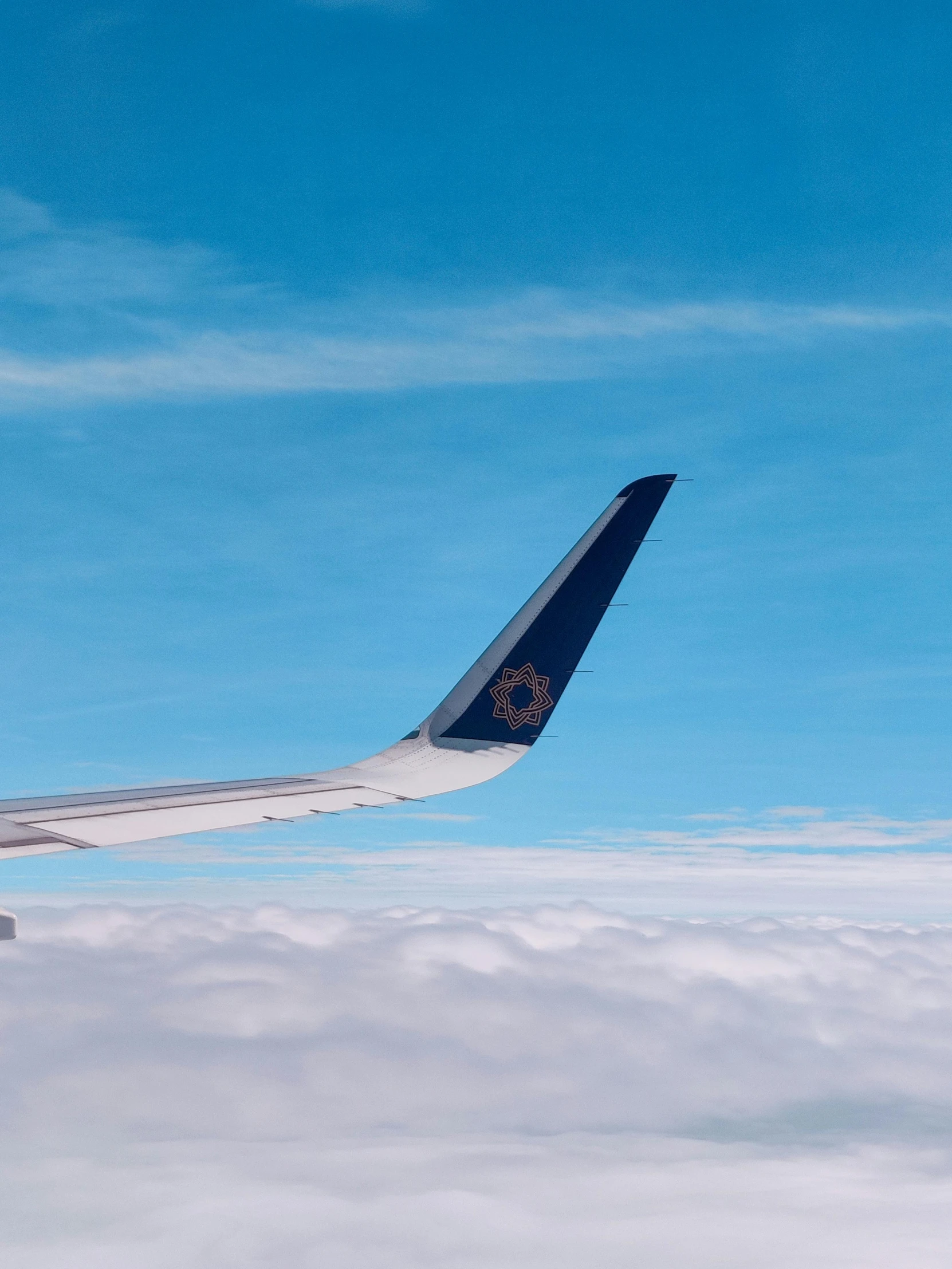 an airplane flying above clouds and a clear blue sky