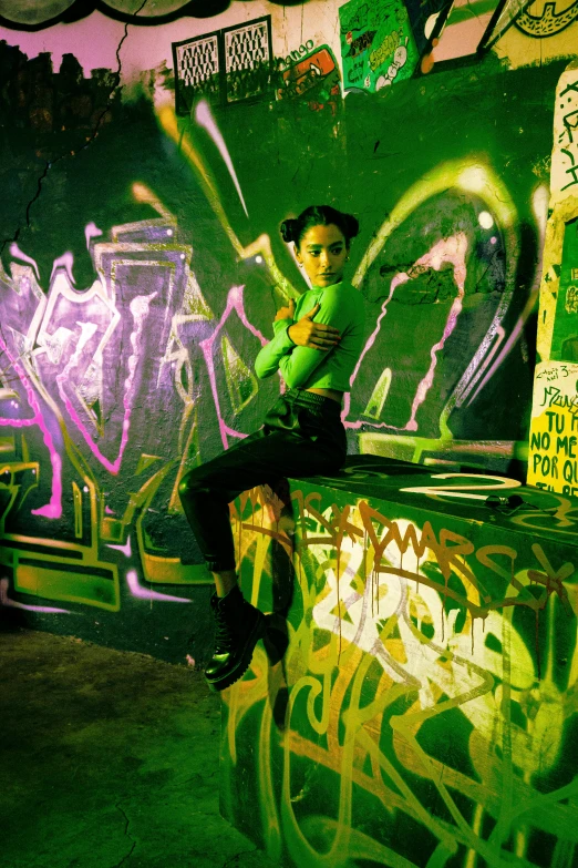 a man is sitting on the wall covered in graffiti