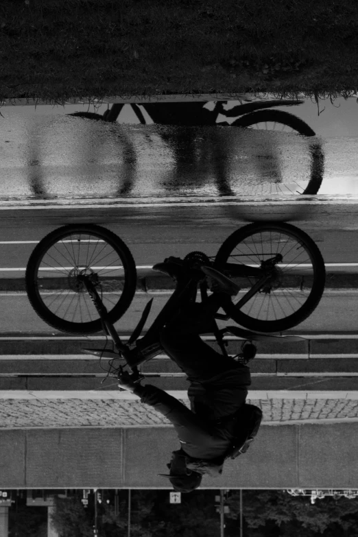 a black and white po of a person jumping on a bicycle