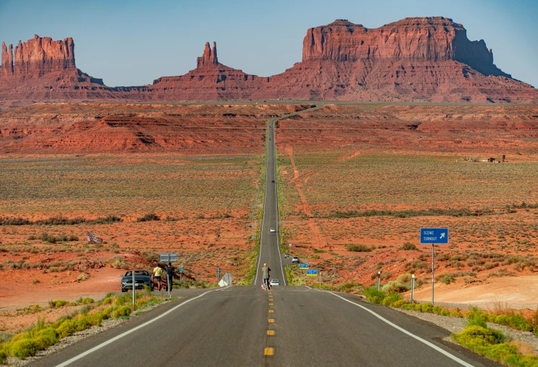 the open road is in front of red mountains