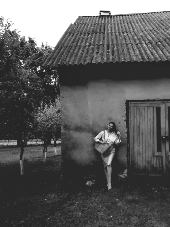 a woman standing by a building with the door open