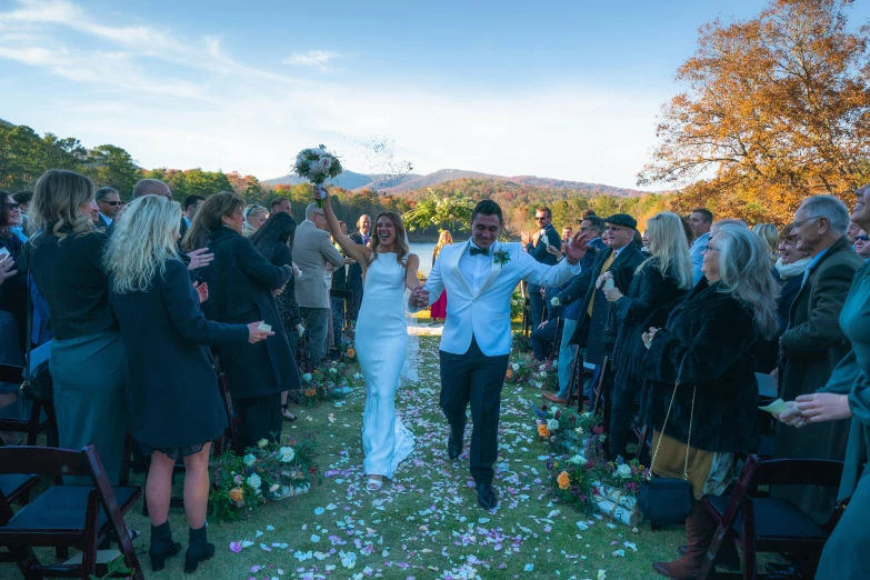 a man and woman walking down the aisle of a wedding ceremony