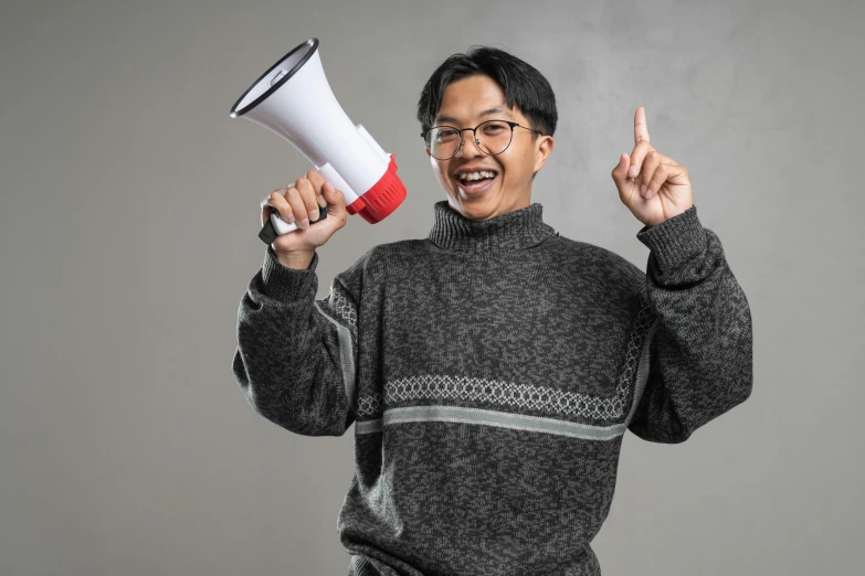 a man in glasses holding a bullhorn with one hand