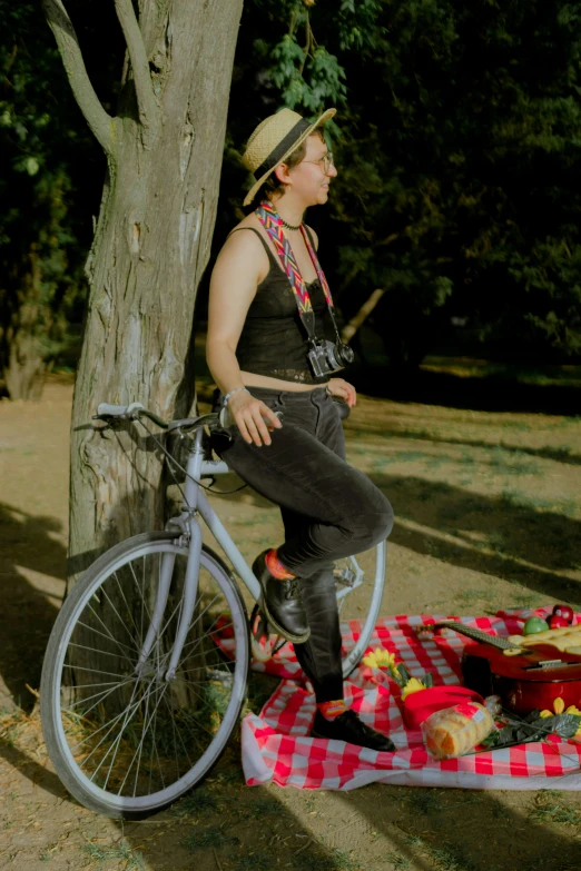 the man is sitting on a bike next to a picnic