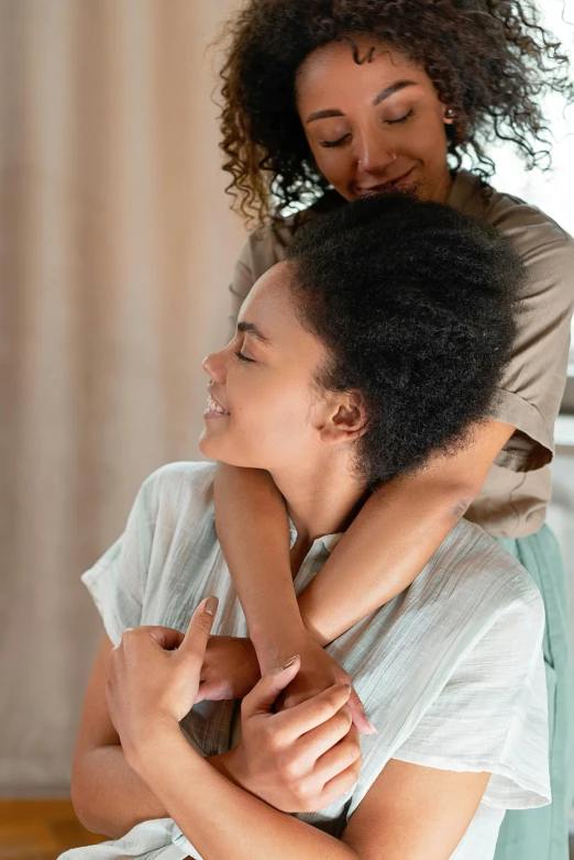 two women hugging each other with one of them holding the other