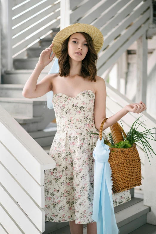 a young woman with a straw hat is holding a basket