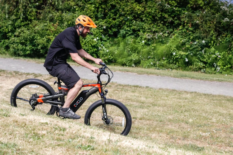 a man riding his bike on a grassy hill