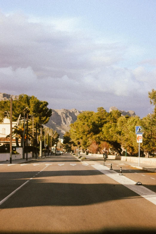 a car parked along a city street next to trees