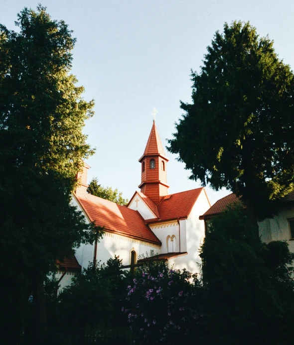 a church with a steeple seen through some trees