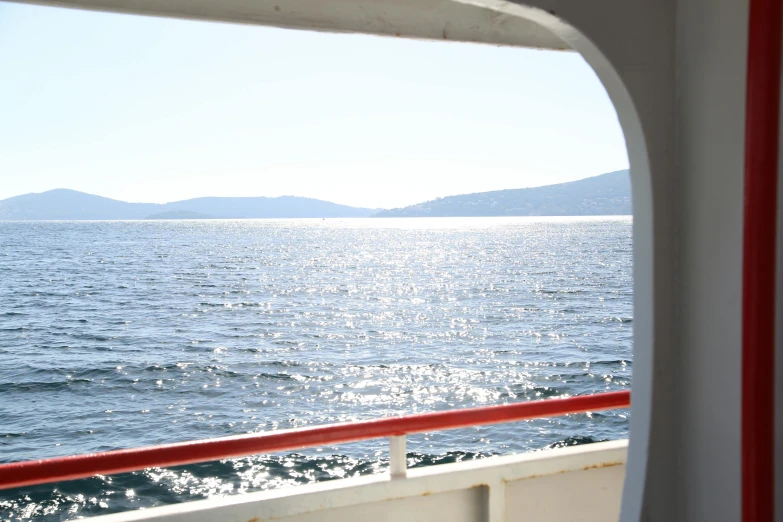 a window looking out on water with mountains in the background