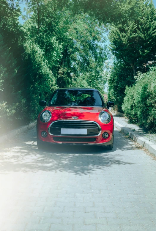 a small red car parked by the side of a road