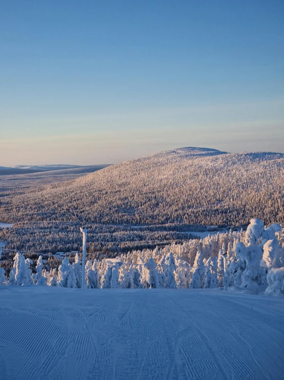 a skier is standing on the top of a snowy hill