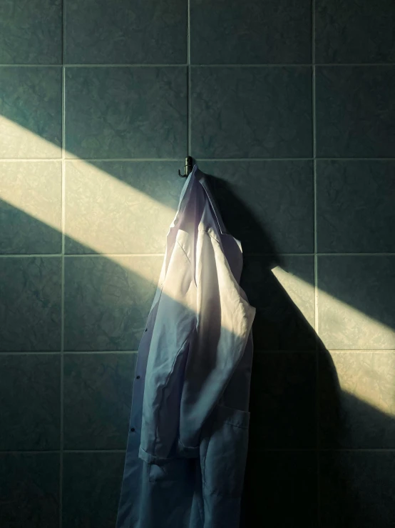 a white shirt hanging from the back on a wall