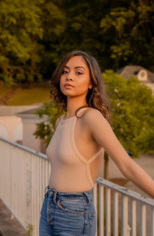 a woman with a back tattoo standing on a fence