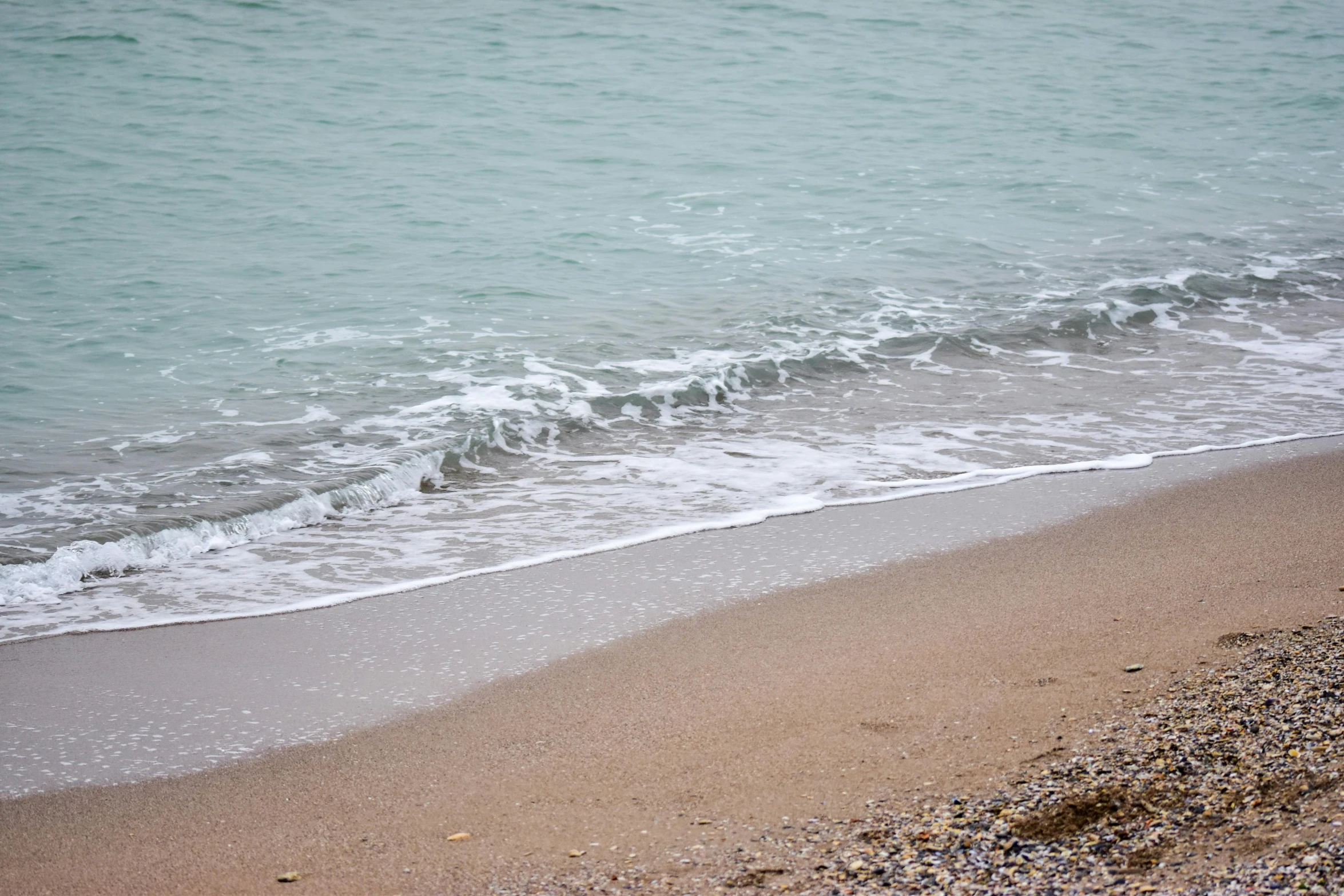 ocean waves rolling on top of the sand