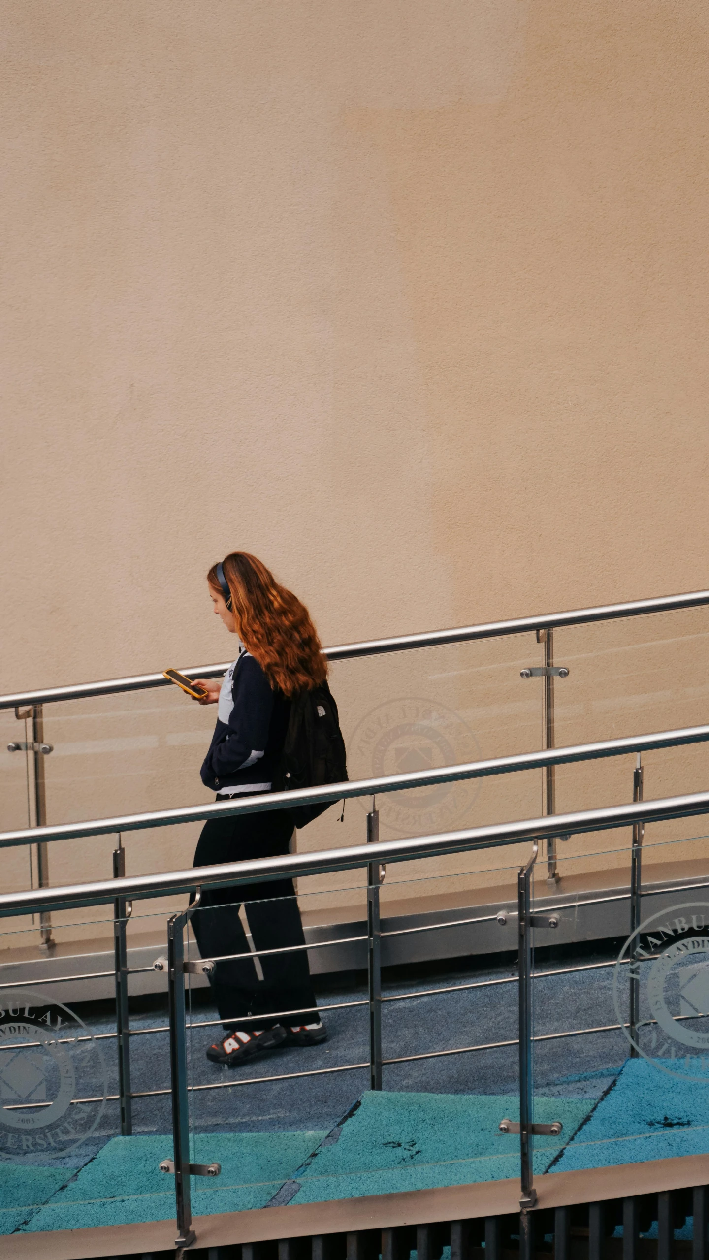 woman walking down steps on the street with cellphone