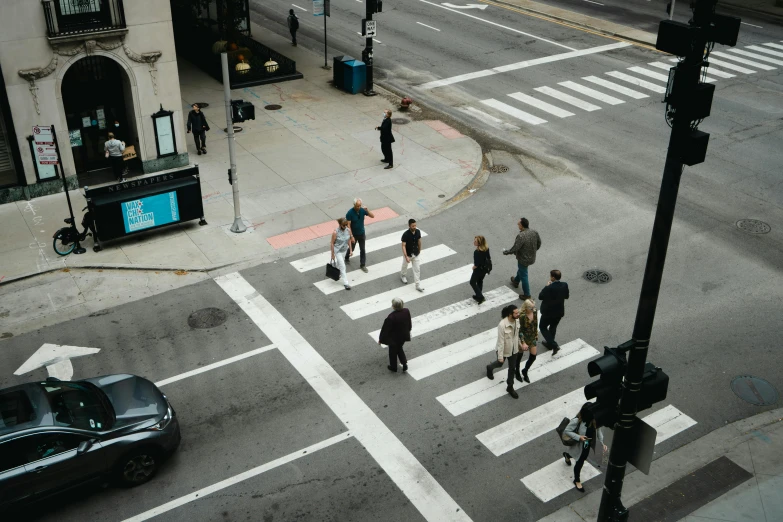 a couple of people crossing the street at a crosswalk