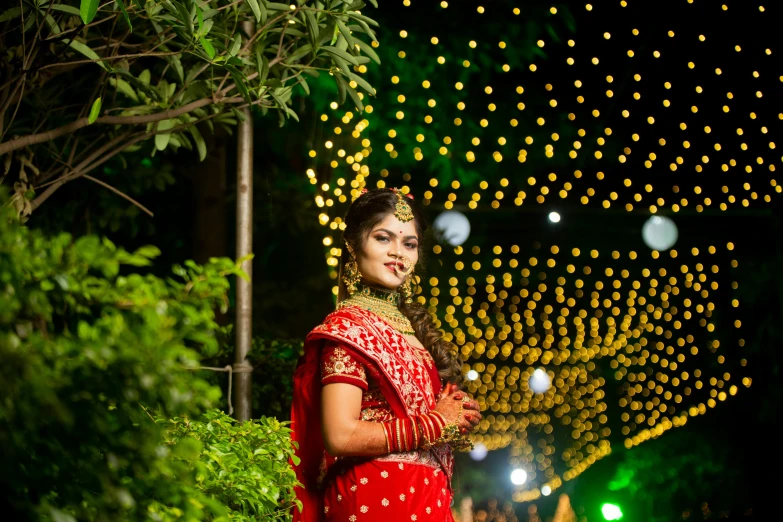 a young woman in a red dress poses for a po with lights in the background