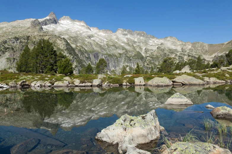 a mountain lake surrounded by green trees and rock formations