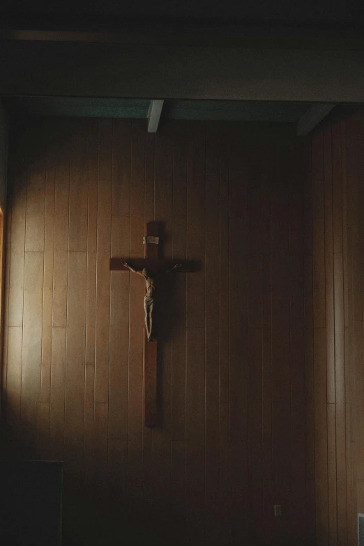 a wooden crucifix hanging on the wall in a dark room