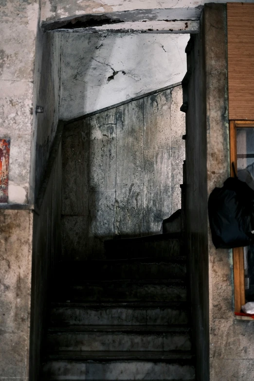 the man looks over his shoulder from beneath stairs