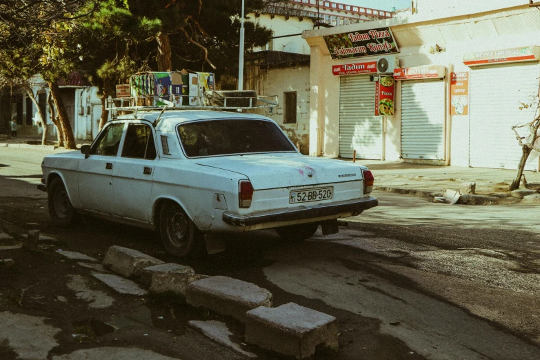 a white car parked on the street near a business