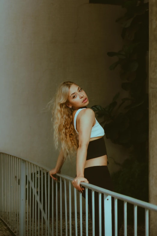 a woman in black shorts is leaning on a metal railing