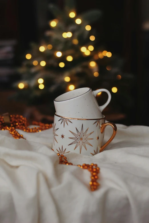 a white cup and some beads on a bed