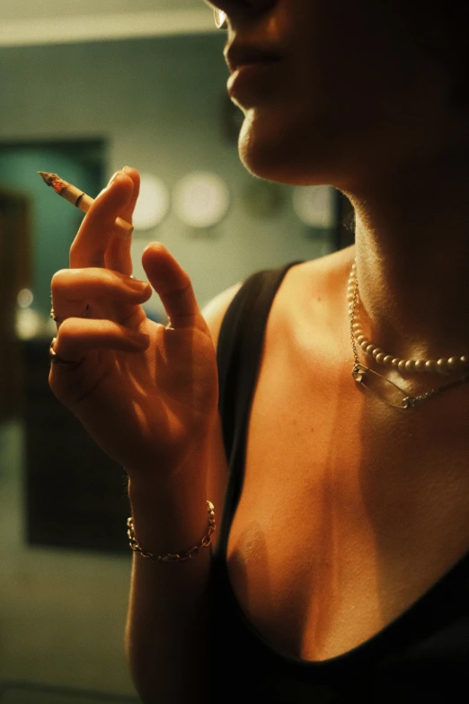 a woman with a necklace and earrings on and a cigarette