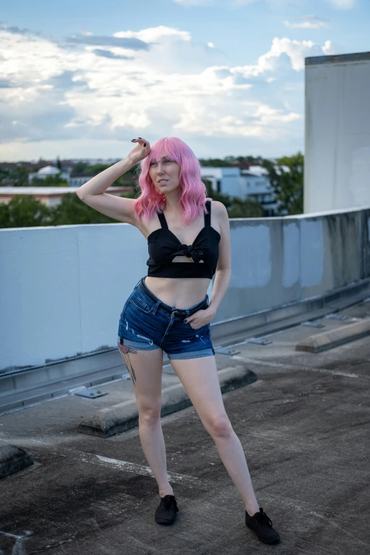 a woman with pink hair is standing on a roof