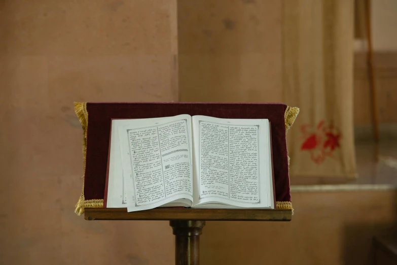 an open book in the foreground is on top of a stand