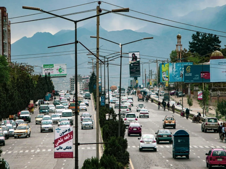 cars on a busy road in a city with mountains