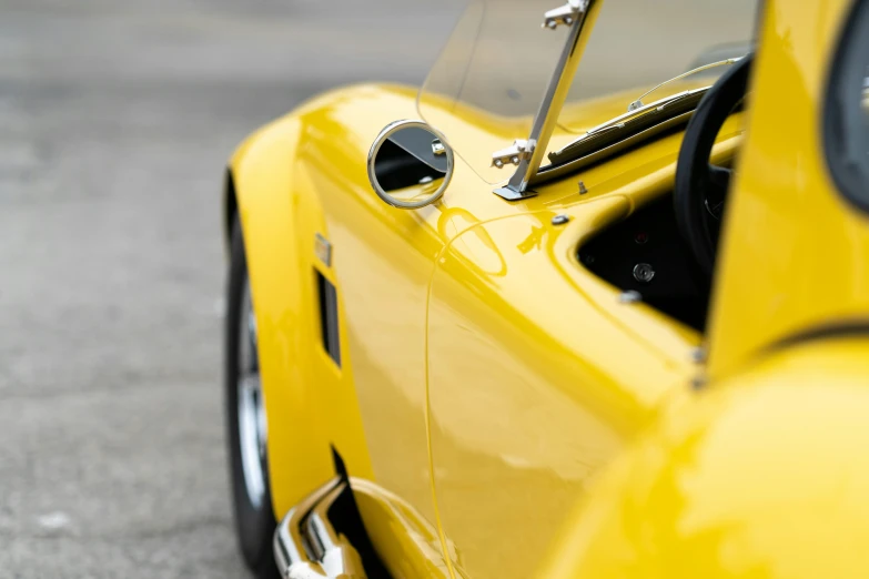 there is a yellow sports car sitting on the street