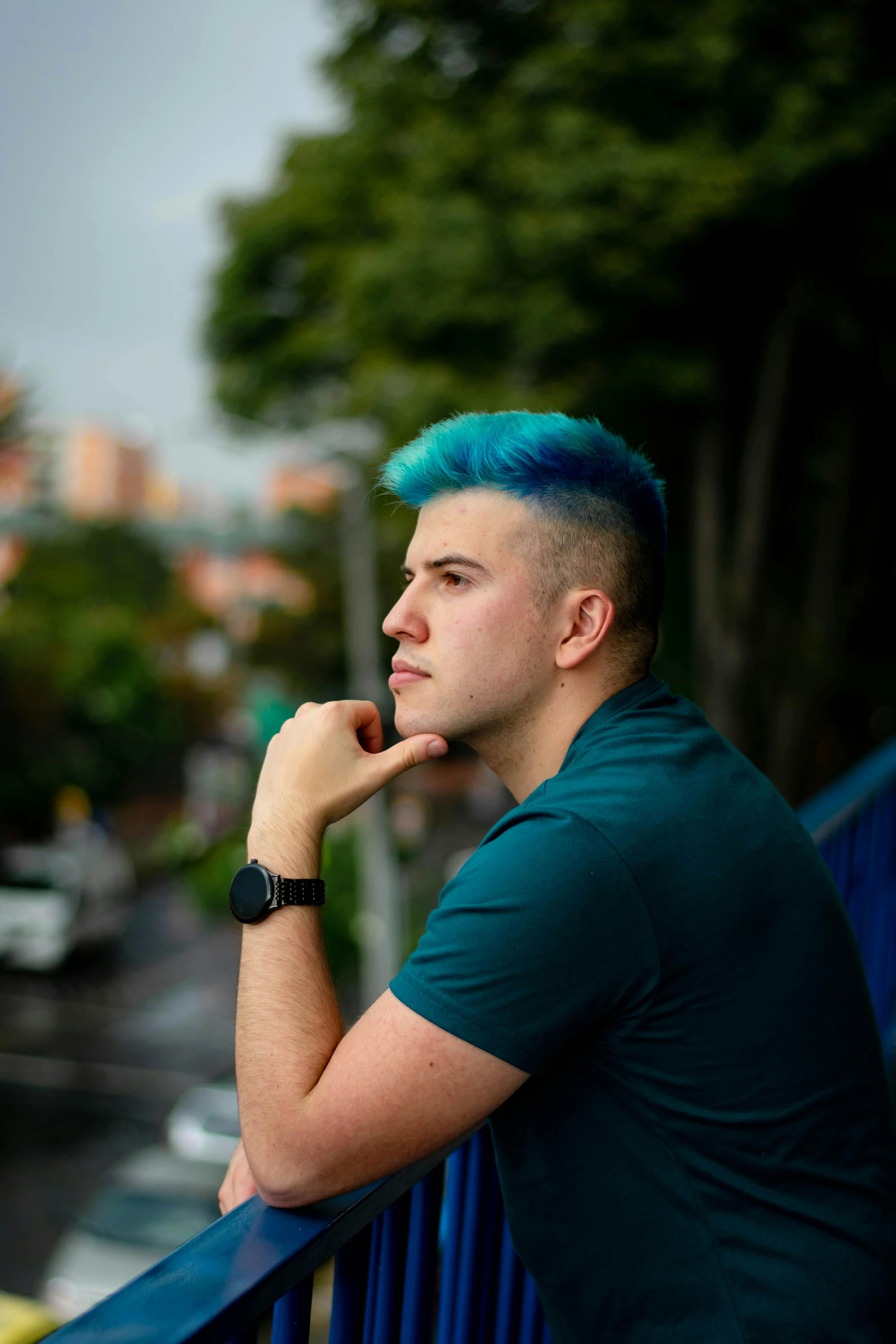 a man with a blue mohawk stares off into the distance