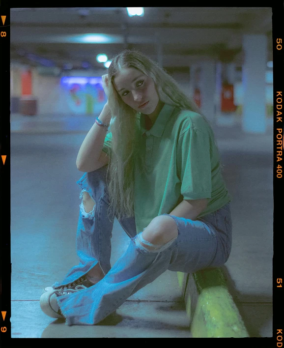 a young woman posing in front of a yellow post