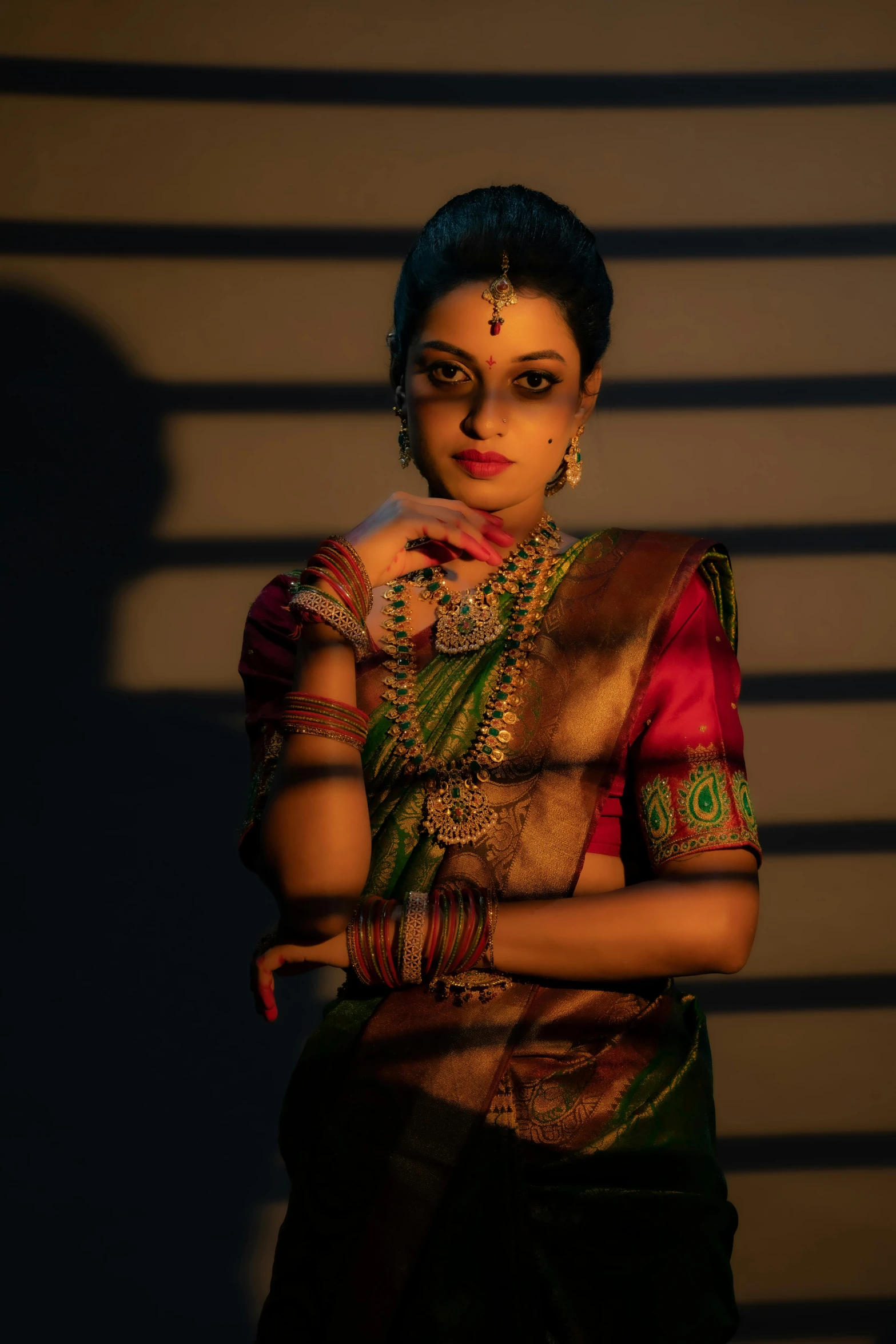 a woman in sari stands with her arms folded in front of her face