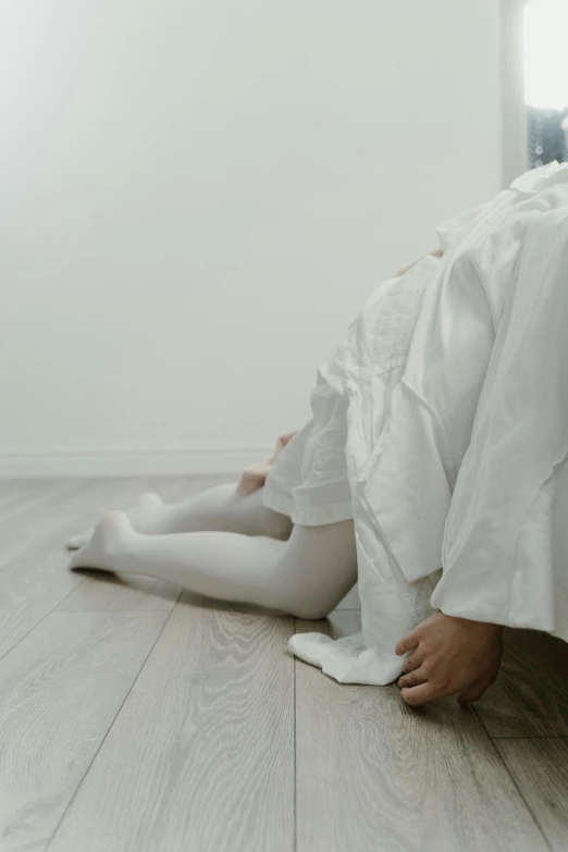 a person laying on the floor wearing all white