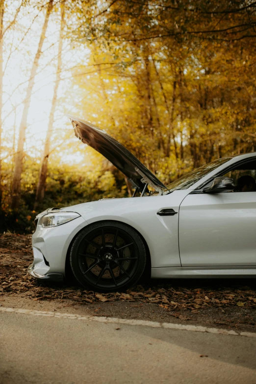 the front view of a white bmw coupe with its open hood up