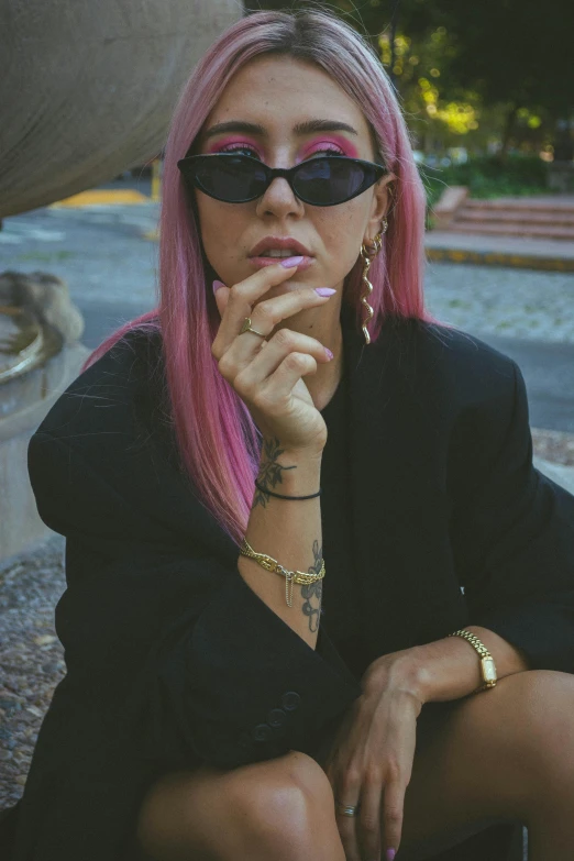 a woman in black dress wearing sunglasses and pink hair