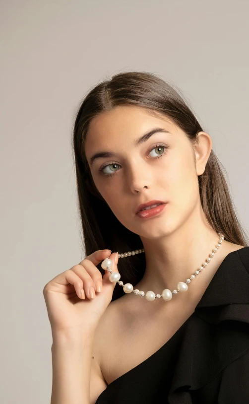 a woman is wearing a pearl necklace on her neck