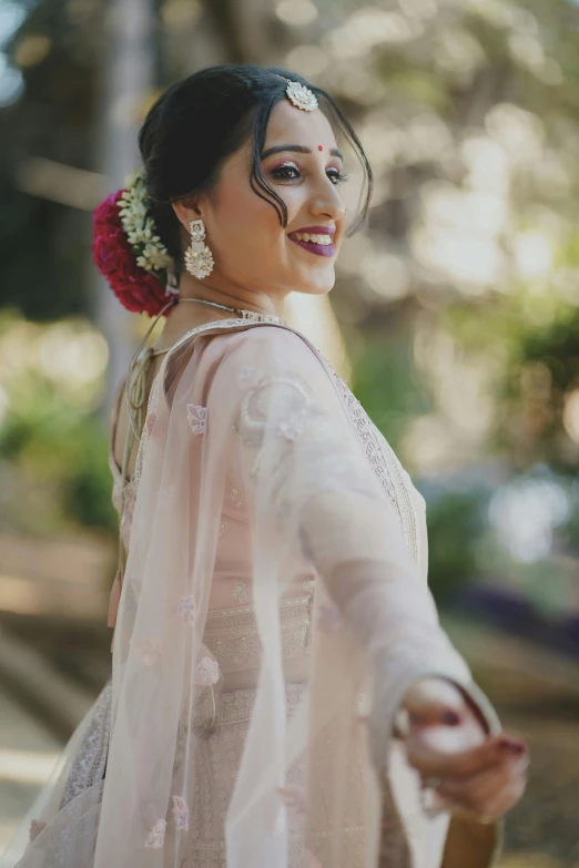 a woman dressed in white, smiles at the camera